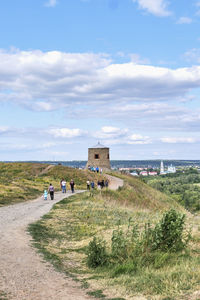 People walking along path to white stone tower, fortress-mosque of 12th century, yelabuga, russia