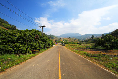 Road amidst trees against sky