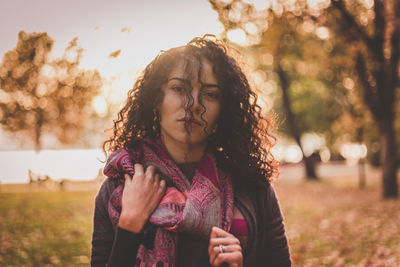 Portrait of beautiful woman standing on field at park