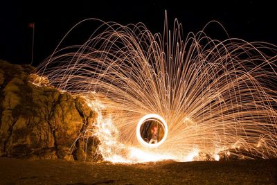 Man spinning wire wool at night