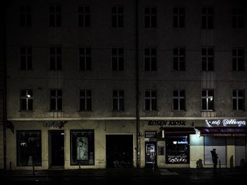People on illuminated building at night