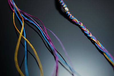 Close-up of colorful threads against gray background