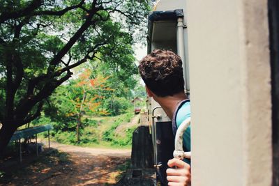 Cropped image of woman holding tree trunk