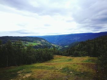 Countryside landscape against cloudy sky