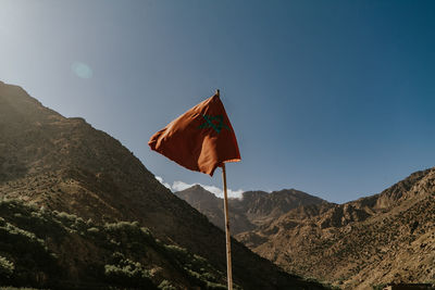 Low angle view of flag against mountain range