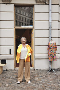 Portrait of smiling female owner with disability standing in front of store