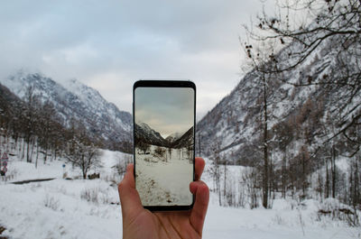 Person holding umbrella on snow covered landscape