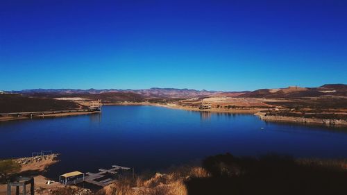 Scenic view of lake against clear blue sky