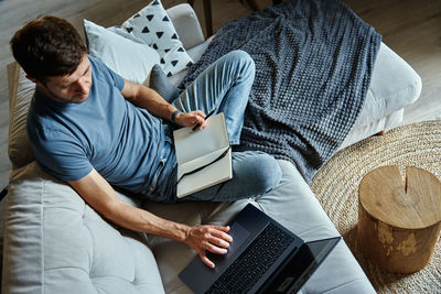 Man sitting on couch and using laptop