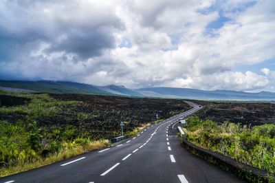 Road passing through landscape against sky