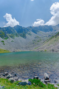 Scenic view of lake by mountains against sky