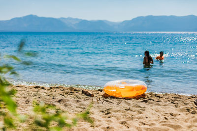 Swimming in a blue mountain lake with an orange inflatable