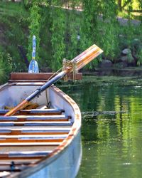 Boat moored on lake against trees