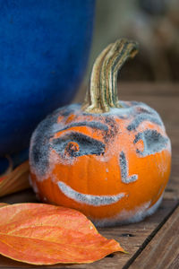 Smiley face on pumpkin at wooden table