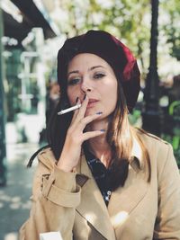 Portrait of young woman smoking cigarette