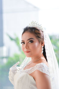 Side view portrait of smiling beautiful bride wearing tiara and wedding dress