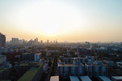 High angle view of city buildings against sky during sunset