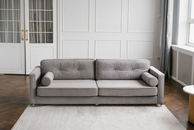 Gray modern sofa in the interior of a cozy living room