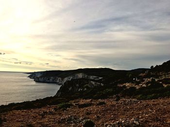 Scenic view of sea and mountains against sky