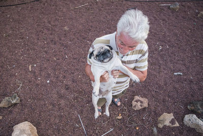 Senior man holding pug