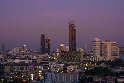 Illuminated buildings against sky at night