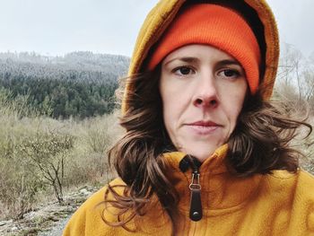 Close-up portrait of woman wearing hat against trees during winter