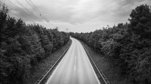 Road amidst trees against sky