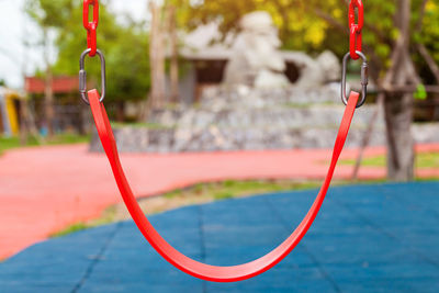 Close-up of red swing at playground