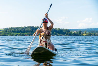 Woman sitting on boat in sea against sky