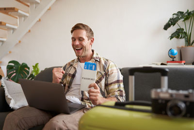 Portrait of young man using digital tablet while sitting at home