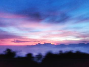 Scenic view of silhouette mountains against romantic sky at sunset