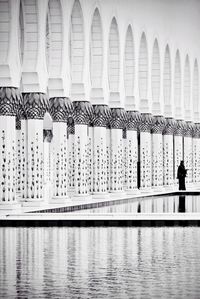 Full length of woman standing by columns at mosque
