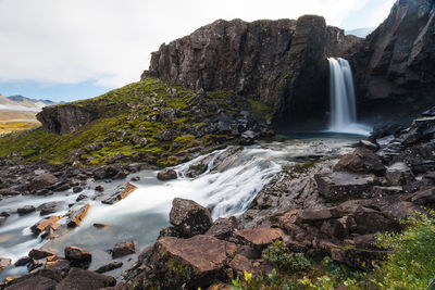 Low angle view of waterfall against sky