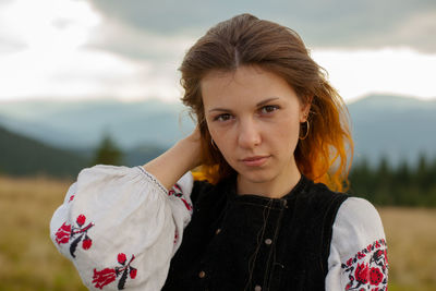 Portrait of a girl in embroidery in the mountains