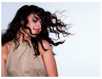 Portrait of young woman against white background