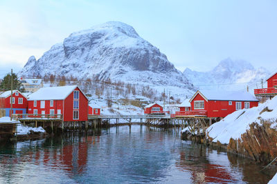 Scenic view of snow covered houses and mountains against sky