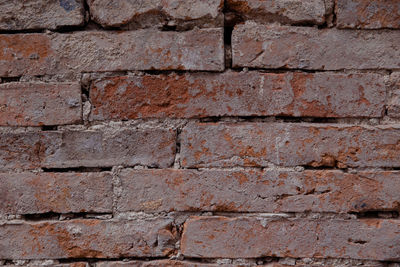 Grunge brickwall with broken stucco texture. old brick wall with damaged shabby gloom plaster layer