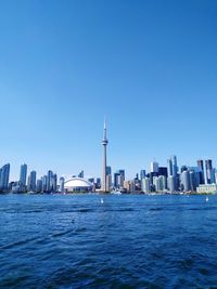 View of city at waterfront against clear sky