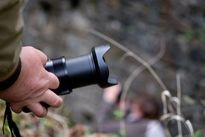 Cropped hand of person holding camera