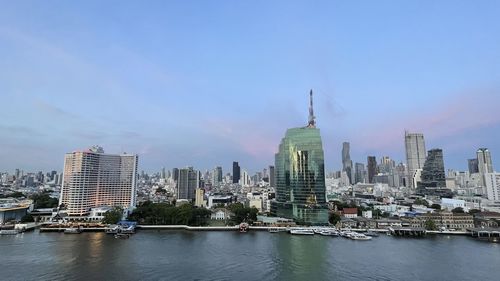 River amidst buildings in city against sky