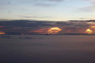 Scenic view of sea against dramatic sky during sunset