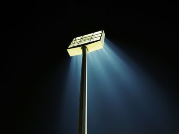 Low angle view of illuminated floodlight against sky