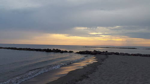 Scenic view of beach against sky during sunset