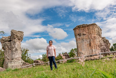 Man standing on rock against sky