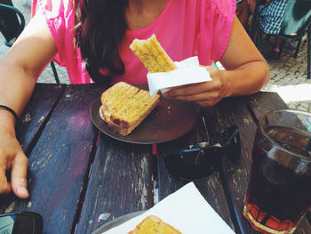 Midsection of woman eating food while sitting at table