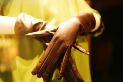 Close-up of hand holding cross against blurred background