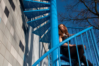 Low angle view of woman looking at railing