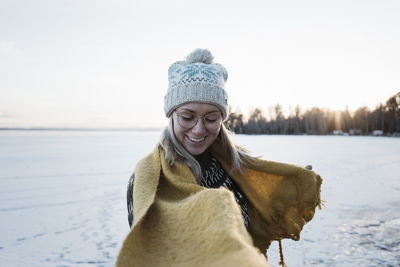 Woman smiling whilst walking on a frozen lake in winter in sweden