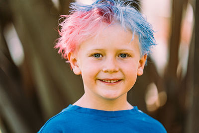 Young boy with colored hair smiling at camera