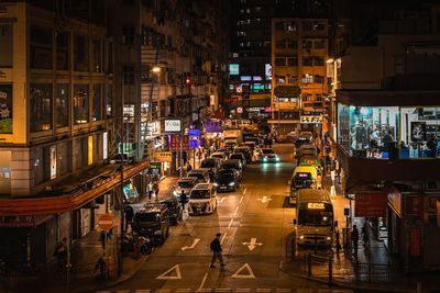 High angle view of illuminated street amidst buildings at night